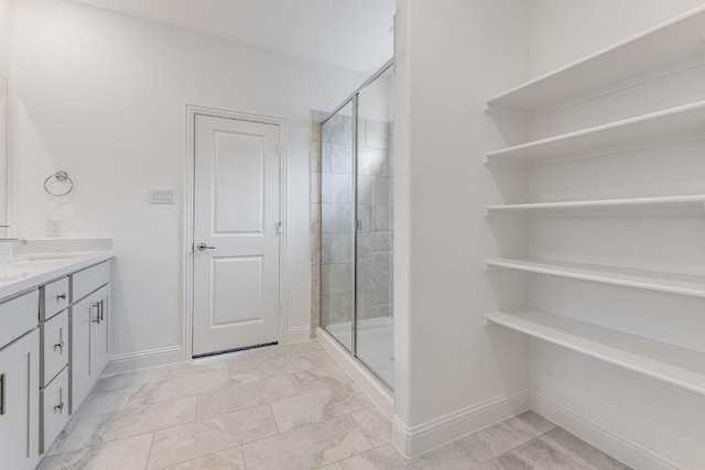 bathroom featuring a stall shower, baseboards, marble finish floor, and vanity