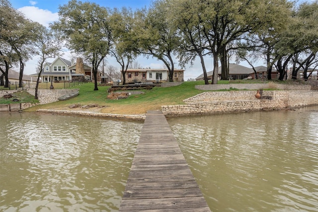 dock area featuring a water view and a lawn