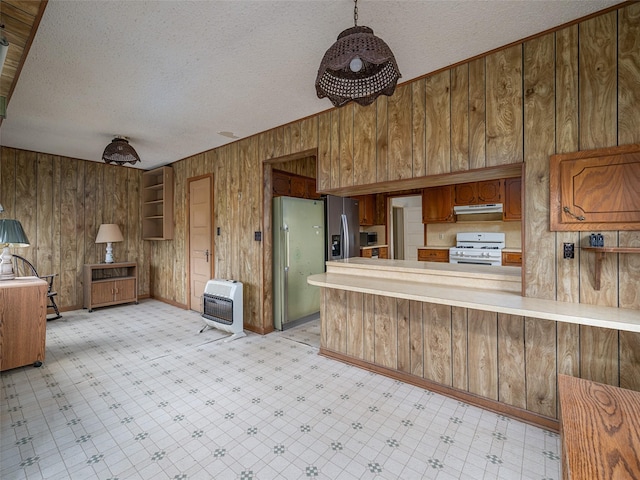 kitchen with heating unit, light floors, appliances with stainless steel finishes, under cabinet range hood, and a peninsula