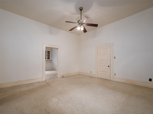 spare room with ceiling fan and baseboards