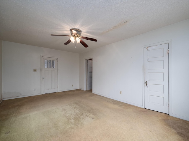 unfurnished room featuring a ceiling fan, light carpet, a textured ceiling, and baseboards