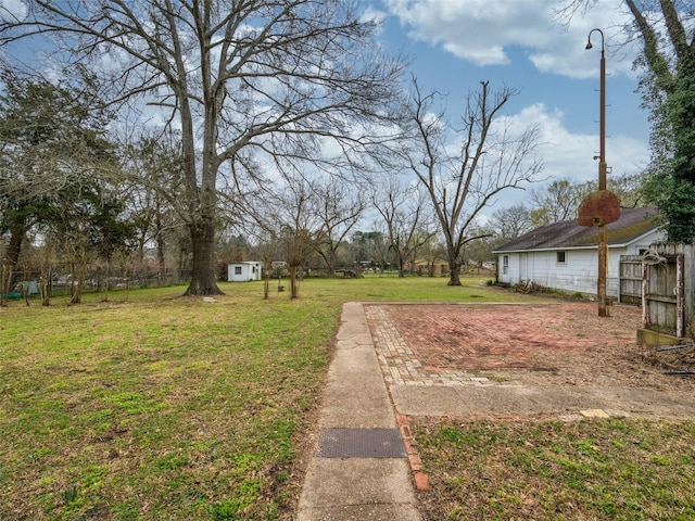 view of yard featuring an outdoor structure and fence