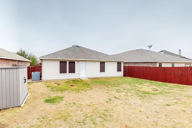 back of property featuring central air condition unit, a fenced backyard, and a yard