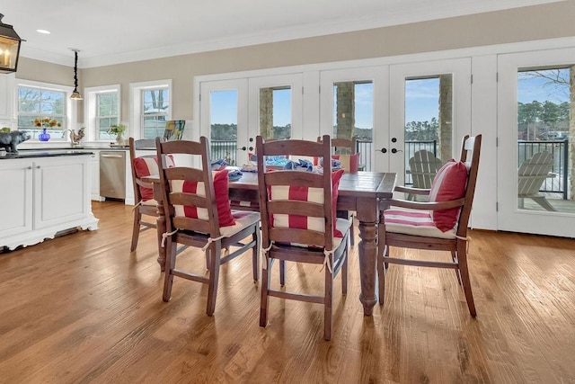 dining space featuring plenty of natural light, ornamental molding, and french doors