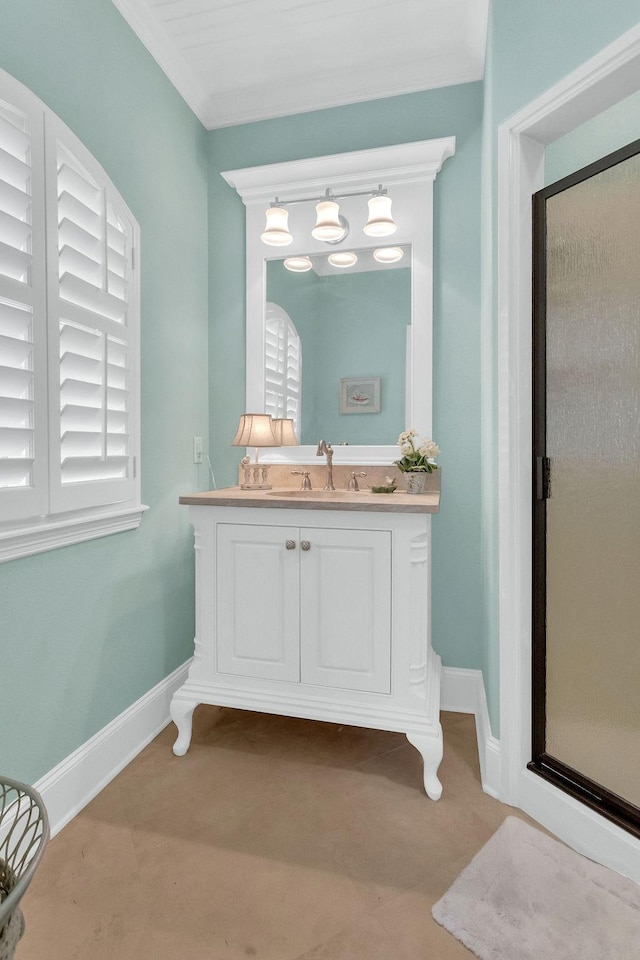 bathroom with a shower stall, baseboards, ornamental molding, and vanity