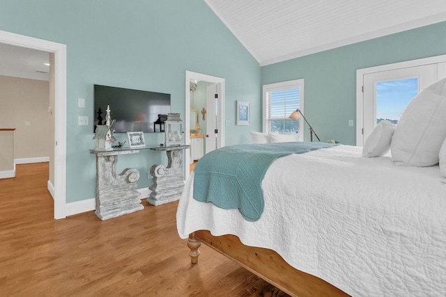 bedroom with baseboards, vaulted ceiling, and wood finished floors