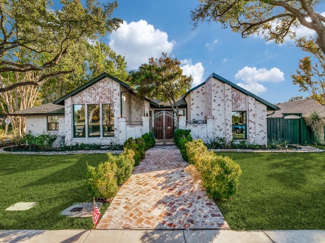 view of front of house featuring a gate, fence, and a front lawn