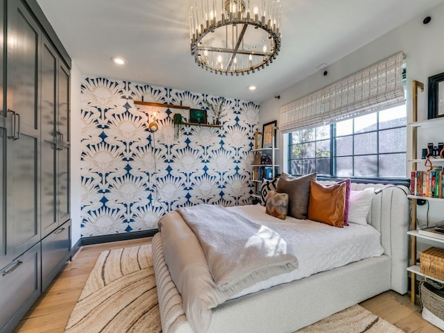 bedroom with recessed lighting, a notable chandelier, and light wood-style flooring