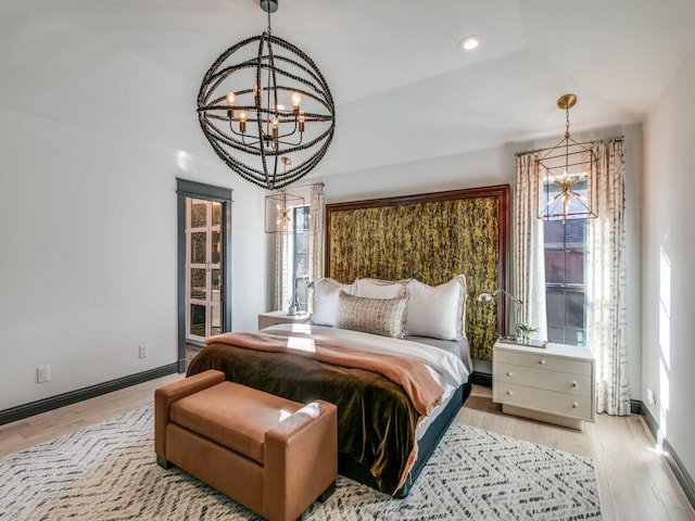 bedroom featuring baseboards, light wood-style floors, recessed lighting, and a notable chandelier