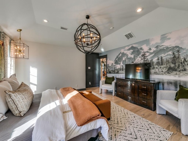 bedroom with light wood finished floors, visible vents, and a notable chandelier