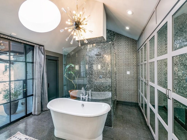 bathroom with tile walls, a freestanding bath, an inviting chandelier, a walk in shower, and tile patterned floors