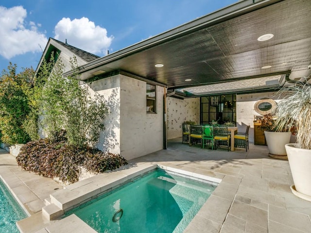 pool with outdoor dining space and a patio area