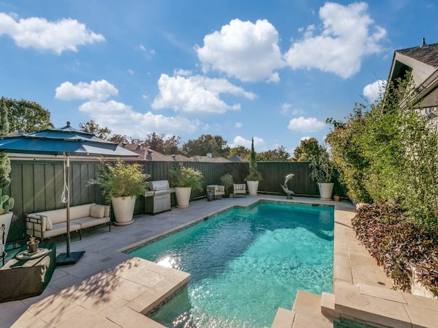 view of swimming pool with a fenced in pool, outdoor lounge area, grilling area, a patio area, and a fenced backyard