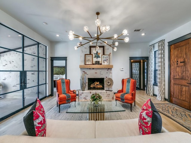 living room featuring recessed lighting, visible vents, an inviting chandelier, a brick fireplace, and wood finished floors