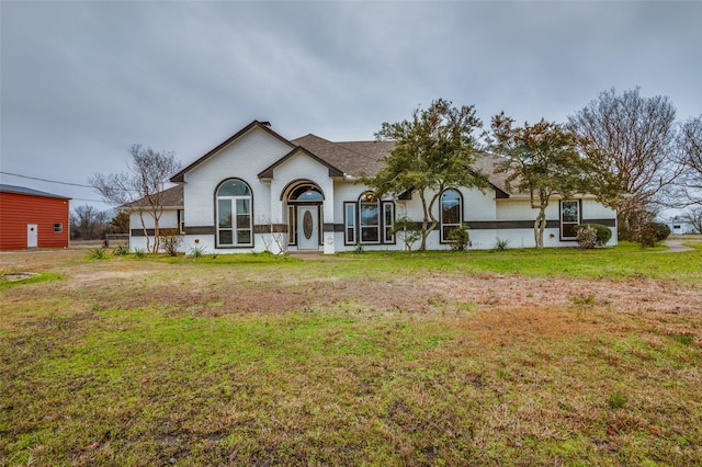 view of front of property featuring a front lawn and brick siding