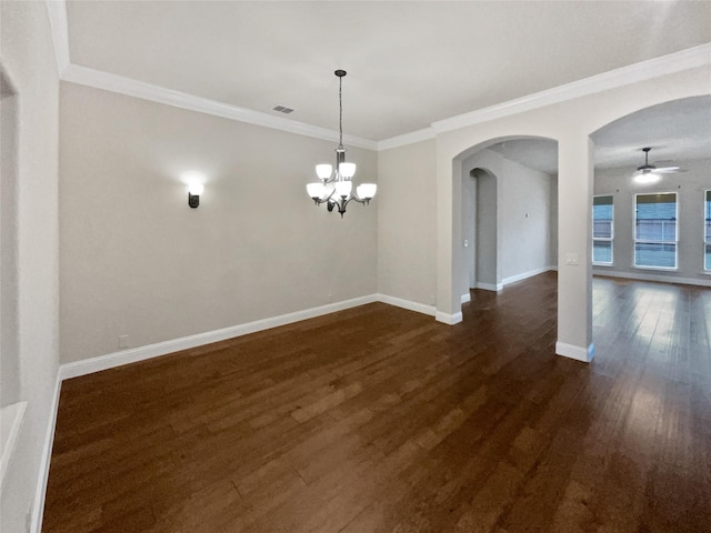 empty room featuring arched walkways, ceiling fan with notable chandelier, baseboards, ornamental molding, and dark wood finished floors