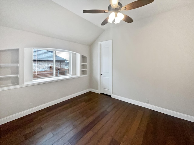 bonus room featuring baseboards, dark wood-style flooring, a ceiling fan, and built in features