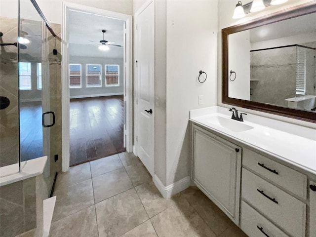 full bath featuring a stall shower, tile patterned flooring, ceiling fan, and vanity