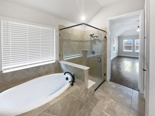 full bathroom featuring tile patterned flooring, a shower stall, vaulted ceiling, and a bath