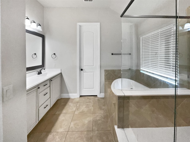 full bathroom featuring visible vents, a bathing tub, vanity, tile patterned flooring, and baseboards