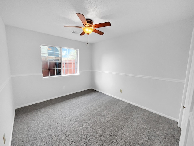 spare room with carpet floors, visible vents, ceiling fan, a textured ceiling, and baseboards