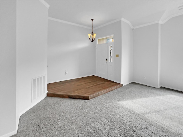 carpeted entryway with a chandelier, baseboards, visible vents, and crown molding