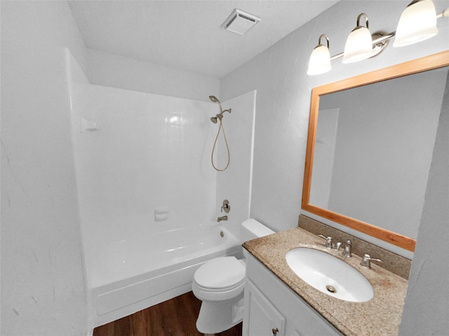 full bathroom featuring shower / bath combination, visible vents, toilet, wood finished floors, and vanity