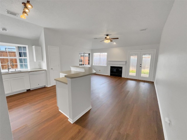 kitchen with visible vents, dishwasher, dark wood-type flooring, white cabinetry, and a sink