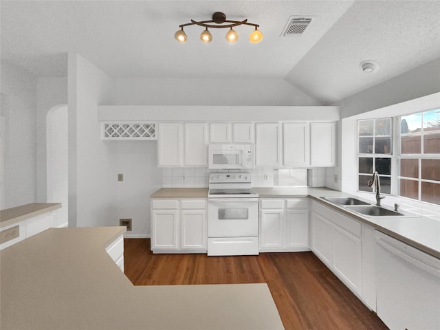 kitchen featuring dark wood finished floors, visible vents, white cabinets, a sink, and white appliances