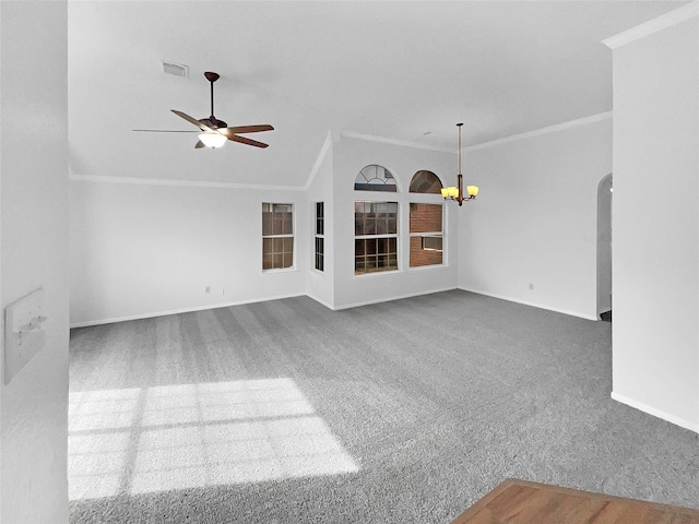 unfurnished living room with arched walkways, ceiling fan with notable chandelier, carpet floors, baseboards, and crown molding