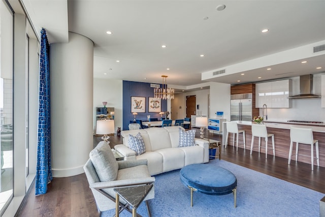 living area with dark wood-type flooring, recessed lighting, visible vents, and a notable chandelier