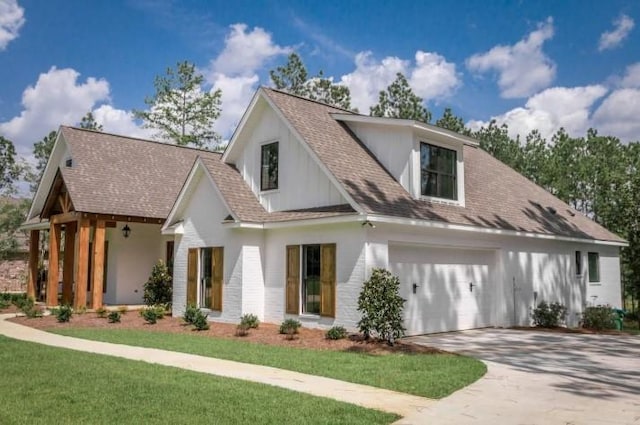 modern inspired farmhouse with driveway, a shingled roof, and a front yard