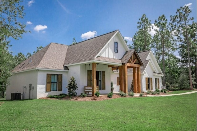 view of front facade with covered porch, central AC, a front lawn, and a shingled roof