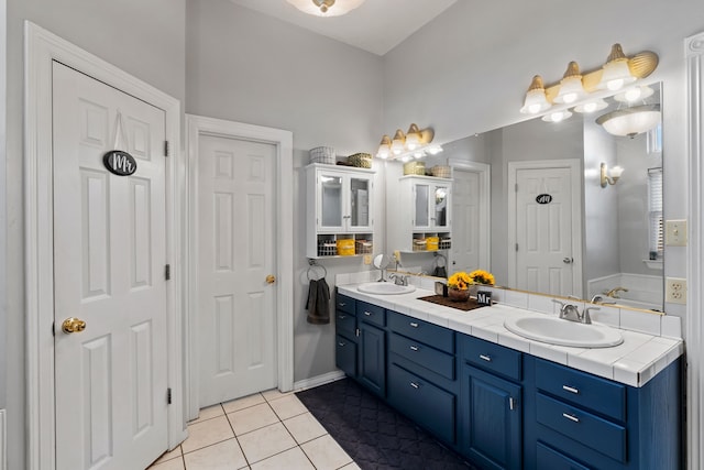 full bathroom featuring double vanity, a sink, and tile patterned floors