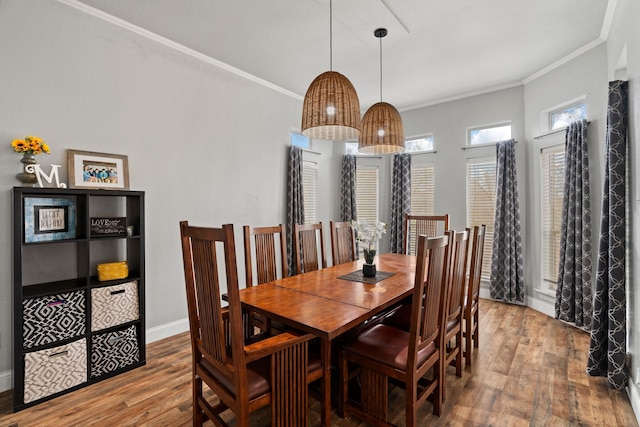 dining area featuring ornamental molding, baseboards, and wood finished floors