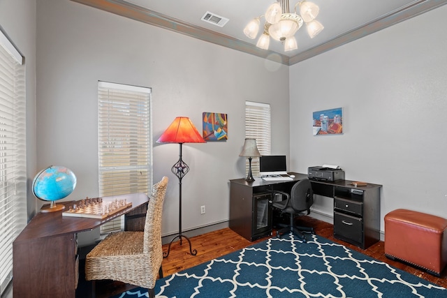 office featuring an inviting chandelier, visible vents, wood finished floors, and ornamental molding