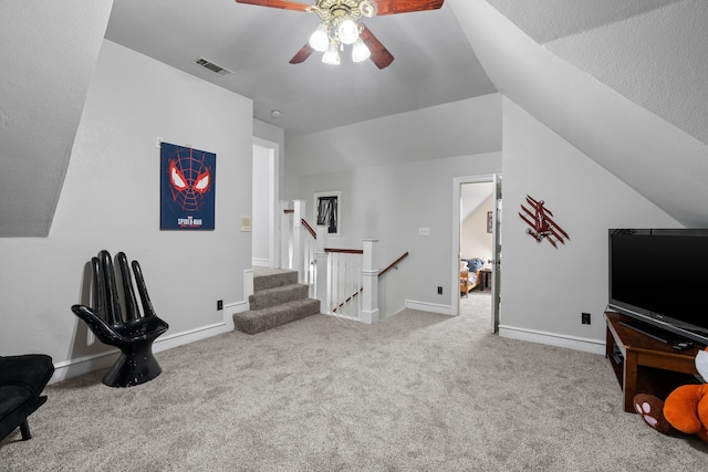 living area featuring baseboards, visible vents, lofted ceiling, carpet flooring, and an upstairs landing