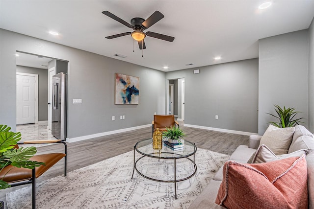 living room with visible vents, baseboards, and wood finished floors