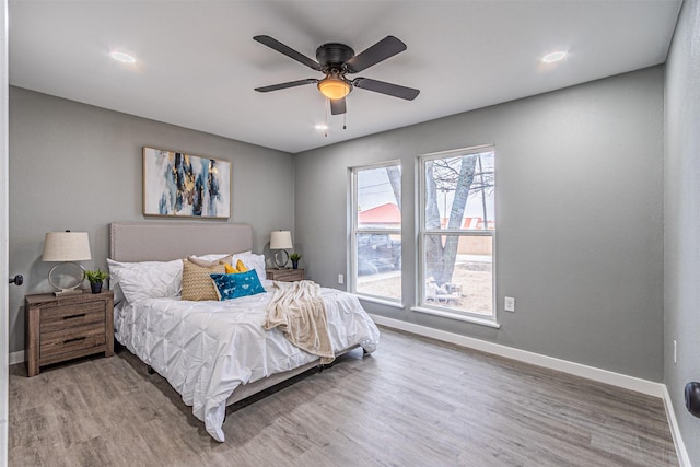 bedroom with a ceiling fan, baseboards, and wood finished floors