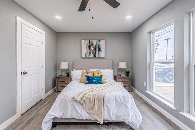 bedroom featuring multiple windows, wood finished floors, and baseboards