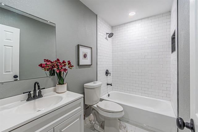 full bath with marble finish floor, a textured wall, toilet, washtub / shower combination, and vanity