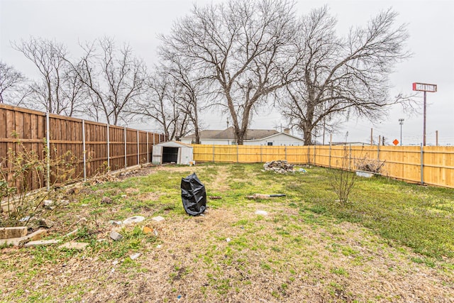 view of yard featuring a storage shed, an outdoor structure, and a fenced backyard