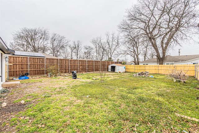 view of yard featuring an outbuilding, a storage unit, and a fenced backyard