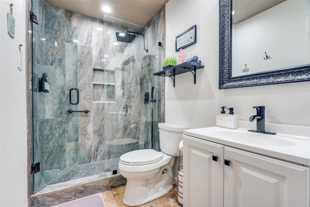 bathroom with a stall shower, vanity, and toilet