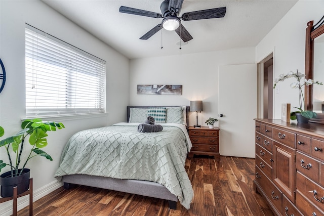 bedroom featuring dark wood-style floors, ceiling fan, and baseboards