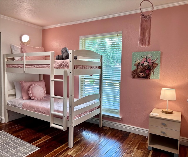 bedroom featuring crown molding, a textured wall, a textured ceiling, wood finished floors, and baseboards