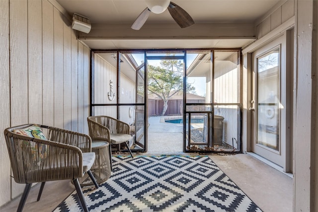 sunroom / solarium featuring ceiling fan and beam ceiling