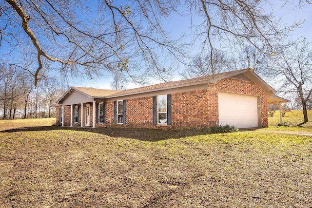 view of property exterior with an attached garage, a yard, and brick siding