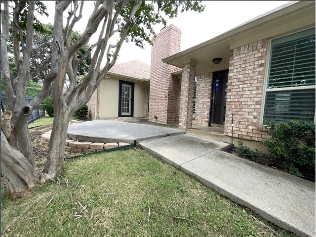 2809 Silverspring Rd, Carrollton, TX 75006 - property entrance with brick siding, a chimney, and a yard