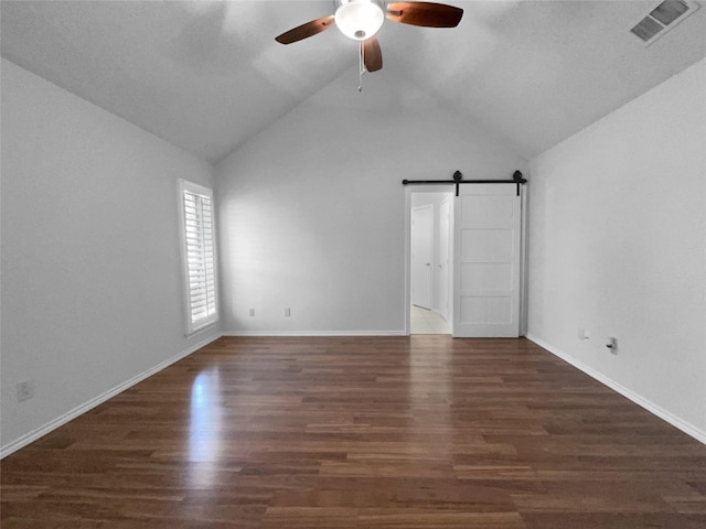 unfurnished bedroom with baseboards, a barn door, visible vents, and wood finished floors